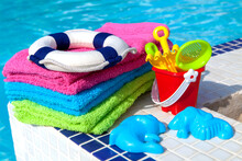 Towels And Children Toys Near The Swimming Pool