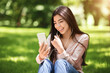 © Prostock-studio - Young asian girl having video call on smartphone while resting in park