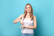 © LumenSt - Beautiful woman showing the word 'to stand' using sign language on blue background