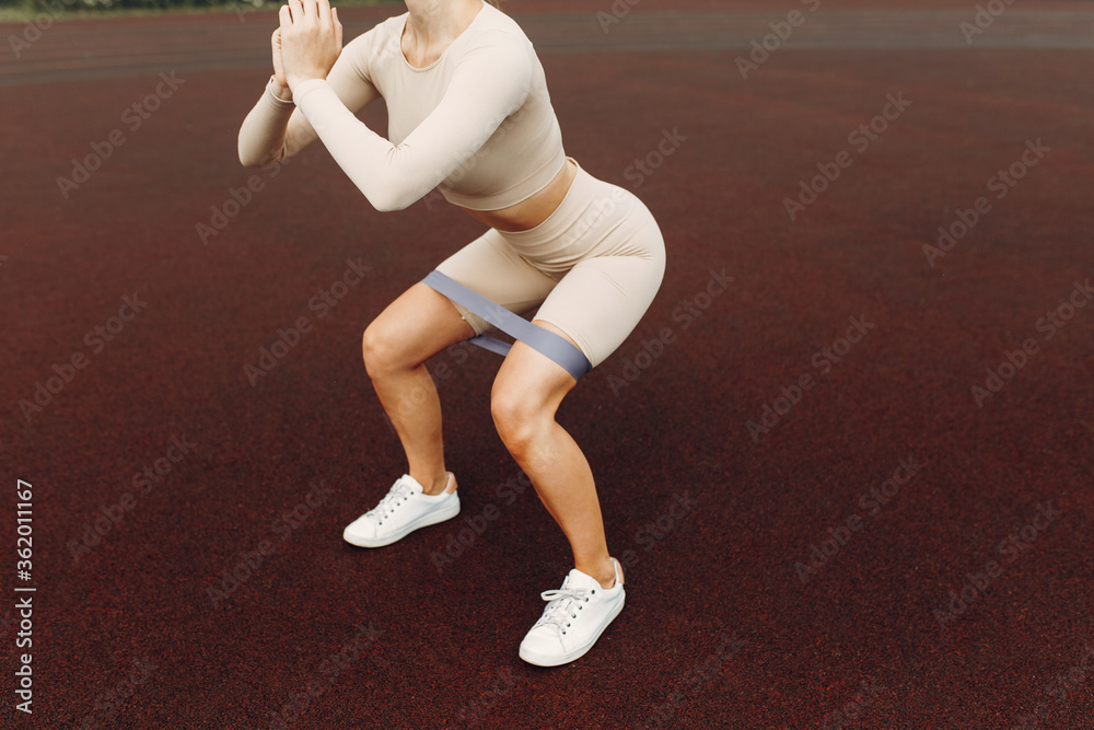 A beautiful girl with a smile is flexing her muscles. Stretches, trains ...