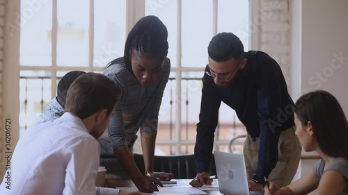 Fotografía Focused diverse business team gather at office table discuss paperwork listen af
