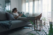 © stokkete - Woman relaxing on the sofa and connecting with her tablet
