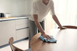 © stokkete - Woman cleaning the kitchen table with a cloth