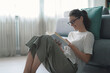 © stokkete - Happy woman sitting on the floor and reading a book