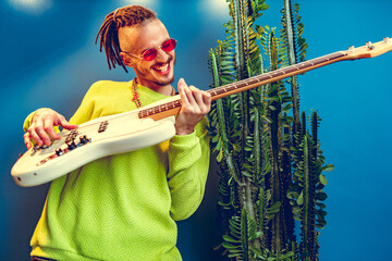 Wall Mural - Cool guy with dreads practicing playing guitar at home