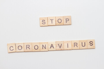 Inscription STOP Coronavirus written wooden blocks on white background. COVID concept