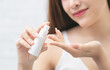 © jayzynism - Smiling young woman applies cream beauty care on her hands.