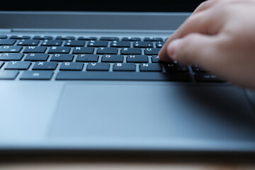 woman is typing on laptop keyboard, selective focus, working in evening at laptop of his house, hand