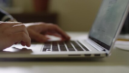 Close up on hands using the trackpad on a laptop