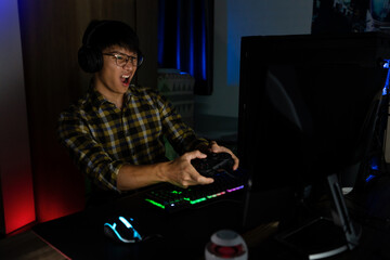 Asian man cyber sport gamer concentrated playing video games on computer eSport concept