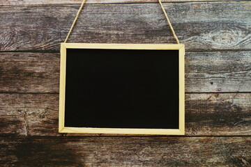 Wall Mural - Empty black board on dark wooden wall texture background