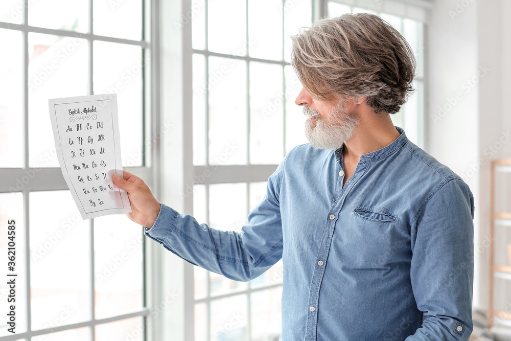 Senior male calligraphist working in office