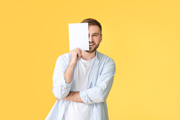 Wall Mural - Young man with blank card on color background