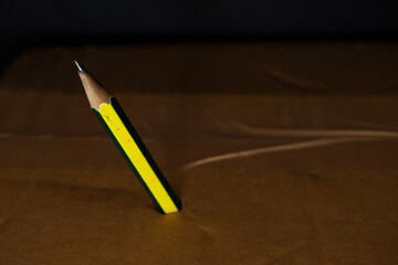 yellow pencil in the table abstract black background