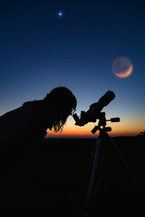 Wall Mural - silhouette of a woman and telescope with twilight sky.