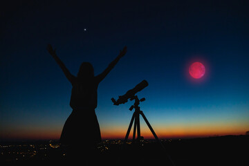 Wall Mural - silhouette of a woman and telescope with twilight sky.