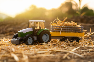 Autocollant - Toy tractor and cart with hay at sunset