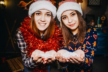 Photo of two friends for the new year. Girls in Christmas costumes.