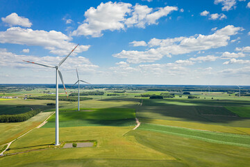 Wind turbines on green field in sunny day, Poland