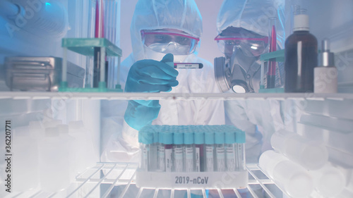 Cuadros en Lienzo Laboratory workers examining covid-19 blood sample from fridge