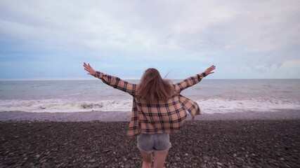 Wall Mural - Young casual carefree free woman in a shirt runs to the sea. Happy moments in life