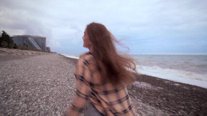 Wall Mural - Young casual carefree free woman in a shirt runs along the sea. Happy moments in life