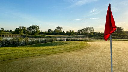 golf green with red flag on pole