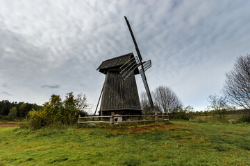 old stone wooden windmill in an open field on a summer day in the pskov region of russia