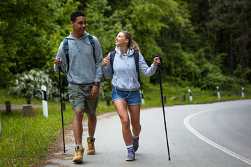 Wall Mural - young mixed race couple hiking in nature.they walking by the old country road.