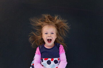 Portrait of a girl with electrified hair on a black background