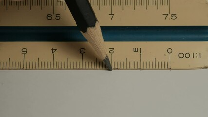 Wall Mural - Male hands using a triangular scale ruler.