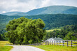 Farm house gravel road wooden fence path in Roseland, Virginia near Blue Ridge parkway mountains in summer with idyllic rural landscape countryside in Nelson County