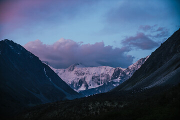 Wall Mural - amazing landscape of sunset with pink snowy mountains and lilac clouds. atmospheric highland scenery