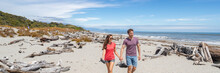 Panoramic Banner Of Couple Walking On Beach In New Zealand - People In Ship Creek On West Coast Of New Zealand. Tourist Couple Sightseeing Tramping On South Island Of New Zealand.