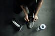 © OMEGA - Woman tying shoe laces. Closeup of female sport fitness runner getting ready for jogging  in gym.