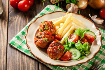 Poster - Roasted meatballs in tomato sauce with french fries and salad