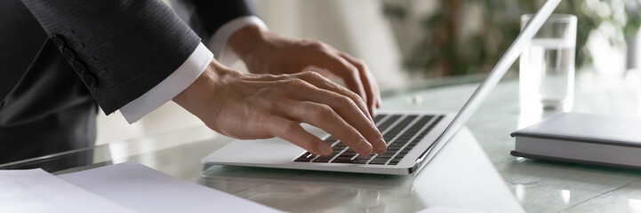 panoramic banner wide view of successful male ceo typing on modern laptop keyboard, browse internet 