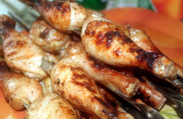 Charcoal-fried chicken shins strung on skewers closeup