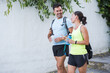 Fitness lifestyle of mature couple walking and talking smiling with backpack and water bottles