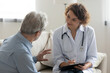 © fizkes - Smiling young female doctor visit mature male patient at home, do regular checkup consultation, happy woman nurse or caregiver talk consult give help to senior man client, elderly healthcare concept