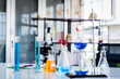 © pornchai - The blue chemicals in the spherical bottles were hung on standby. With the burners below With glass equipment Used for laboratory experiments such as beakers, cylinder, flask, dropper