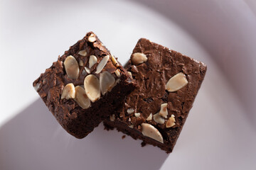 Two almonds brownies on a natural wood background