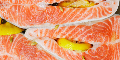 Trout. Fresh raw trout steaks with culinary ingredients and lemon. Top view.