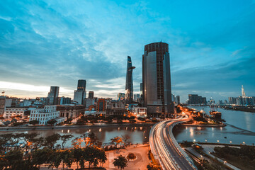 Wall Mural - Ho Chi Minh city at sunset, Khanh Hoi bridge, yellow trail on street, the building in picture is bitexco tower, Far away is landmark 81 skyscraper