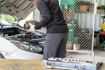 Wall Mural - Mechanic man holding starter motor of the car on working table in repair and maintenance garage