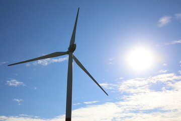 Wind turbine against beautiful blue sky. Alternative energy source