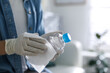 Woman cleaning bottle with wet wipe indoors, closeup. Coronavirus pandemic
