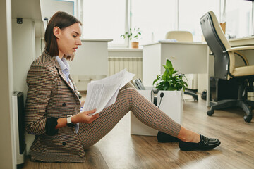 Poster - Young contemporary businesswoman in smart casualwear sitting on the floor
