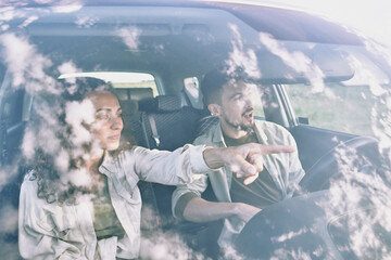 Canvas Print - Young woman with curly hair pointing forwards while sitting in car by husband