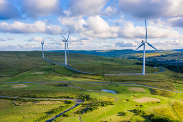 Wall Mural - Aerial drone shot of several clean energy wind turbines in a rural area of South Wales, UK